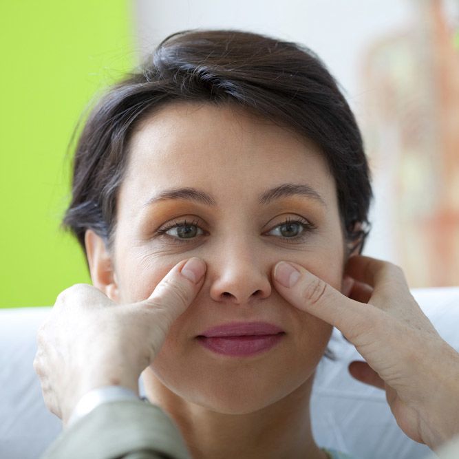 photo of a woman's nose being examined by Rhinoplasty Surgeon in Little Rock, AR